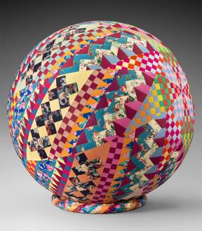 A multi-colored quilt wrapped around a spherical ball