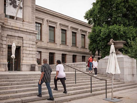 Two visitors walking up the front steps of the Museum