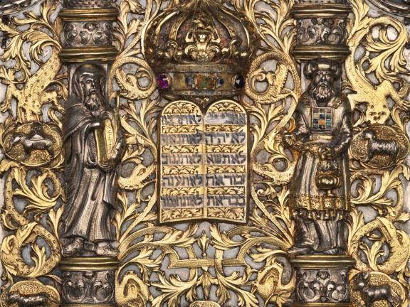 A detail of a silver Torah shield depicting the figures of Moses and Aaron.