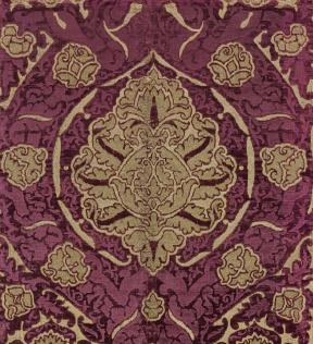 A piece of deep red velvet adorned with a gold velvet design. 