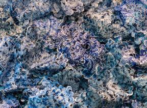 Blue-and-white shell-like pieces of plastic interlocked to resemble a wave. 