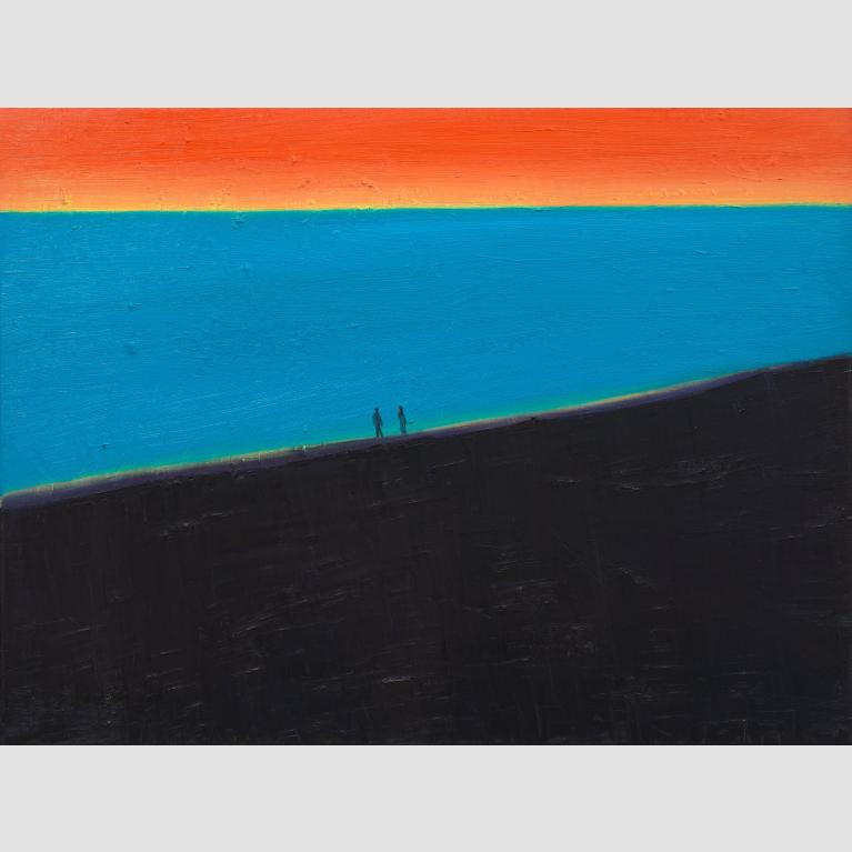 Two people walk along a black-sand beach at sunset.