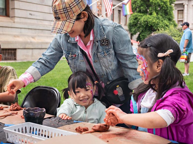 A mother and two daughters take part in face painting activities on the Huntington Lawn
