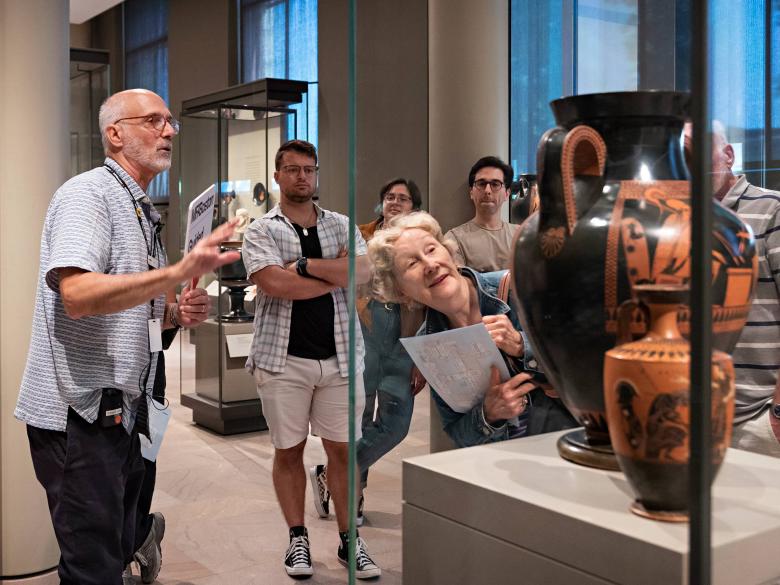A tour group listens to an MFA tour guide speak about a group Ancient pots. 