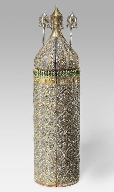 An ornate, cylindrical wood and silver Torah case. 