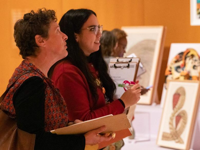 An educator and an MFA staff member discuss a piece of art during an educator workshop