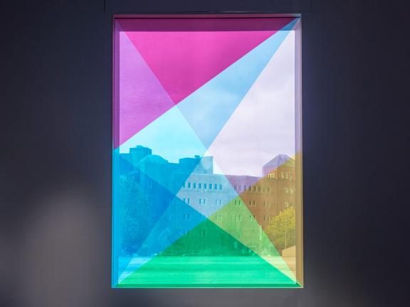 A window with various triangles of neon color overlayed across the pane.