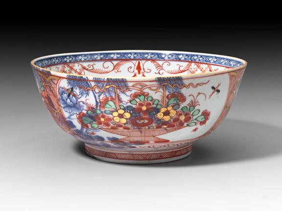 A blue-and-white punch bowl with elaborate enamel ornamentation on its surface.