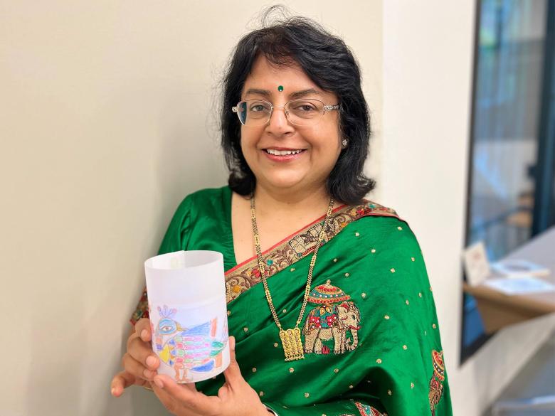 Artist Sunanda Sahay holding completed paper lantern with a peacock design