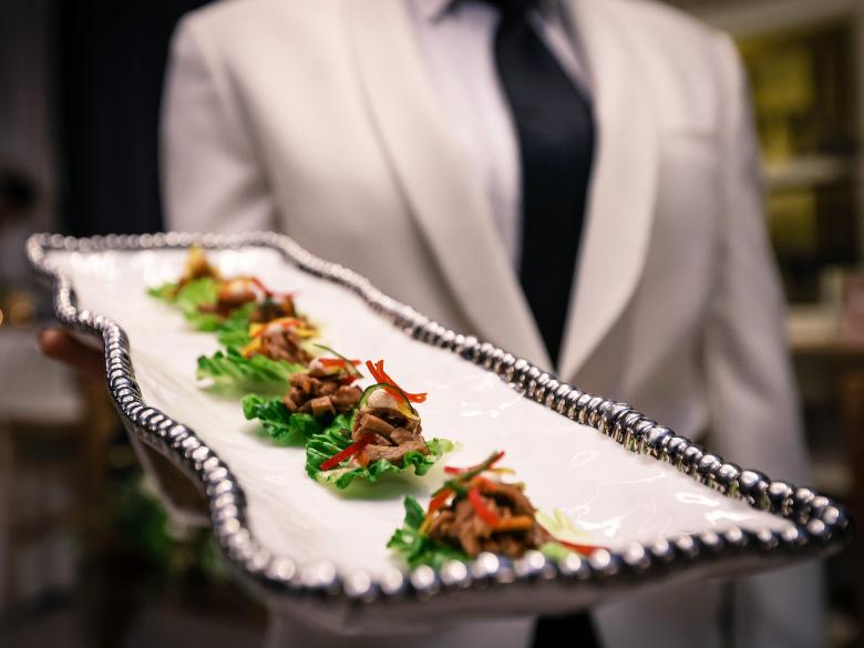 A waiter offers a tray of appetizers 